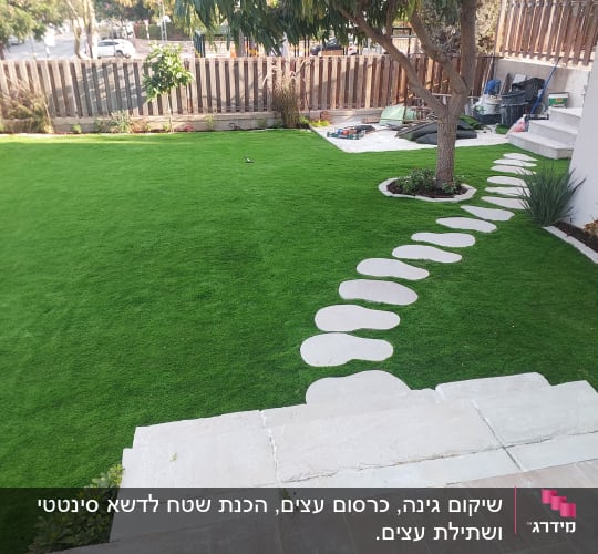 גינה עם דשא מלאכותי ושביל אבנים